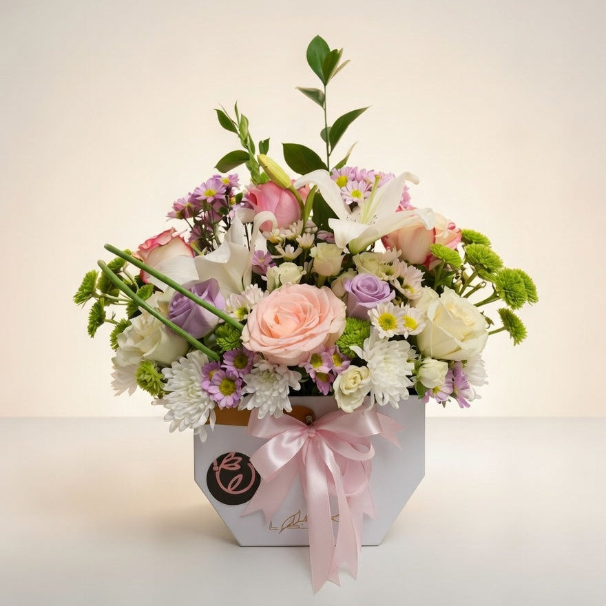 Bouquet of flowers in a box with a pink bow on a light background