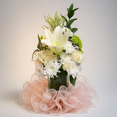 Bouquet of flowers with a pink ruffled base on a light gray background