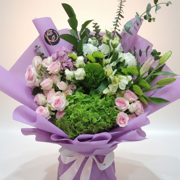 Bouquet of flowers wrapped in purple paper with a logo on a white background