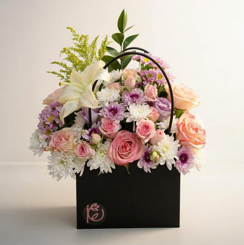 Floral arrangement in a black box with a soft light background
