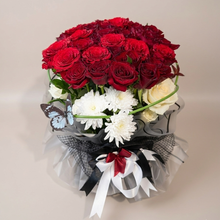 Bouquet of red and white flowers with ribbons on a beige background